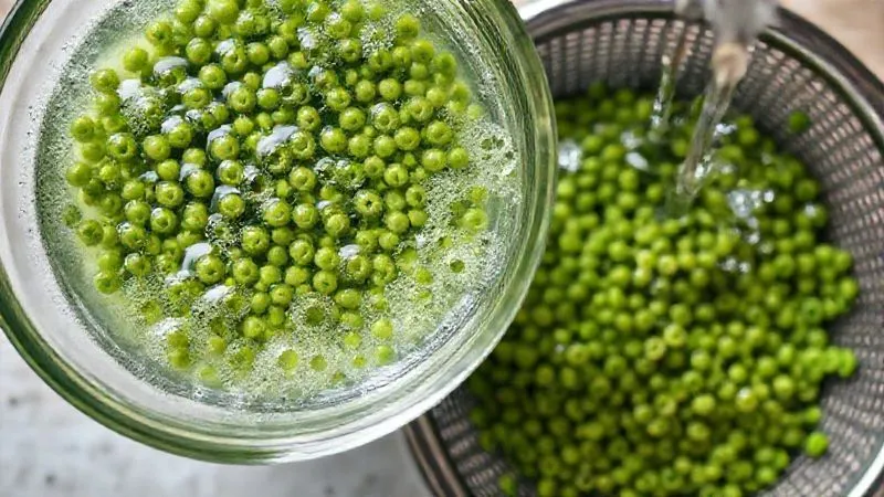 A close-up, top-down shot of a glass bowl filled with green lentils soaking in water, with small bubbles forming, emphasizing the soaking process. Next to it, a colander with rinsed lentils under a gentle stream of clear water, showing the cleanliness. The scene should be bright, clean, and focus on the preparation steps, photorealistic, professional photography, 8K, cinematic lighting, sharp focus, depth of field, shot on a high-end DSLR.