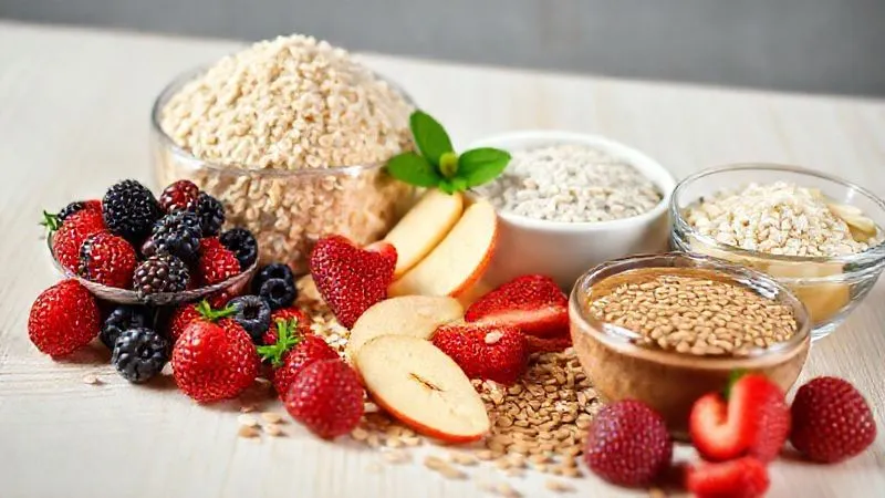 Photorealistic, professional photography, 8K, cinematic lighting, sharp focus on a collection of healthy gluten-free baking ingredients: gluten-free oat flour, almond flour, erythritol, fresh berries, unsweetened apple sauce, and a bowl of flax seeds. All arranged on a clean, light wooden table, depth of field, shot on a high-end DSLR.