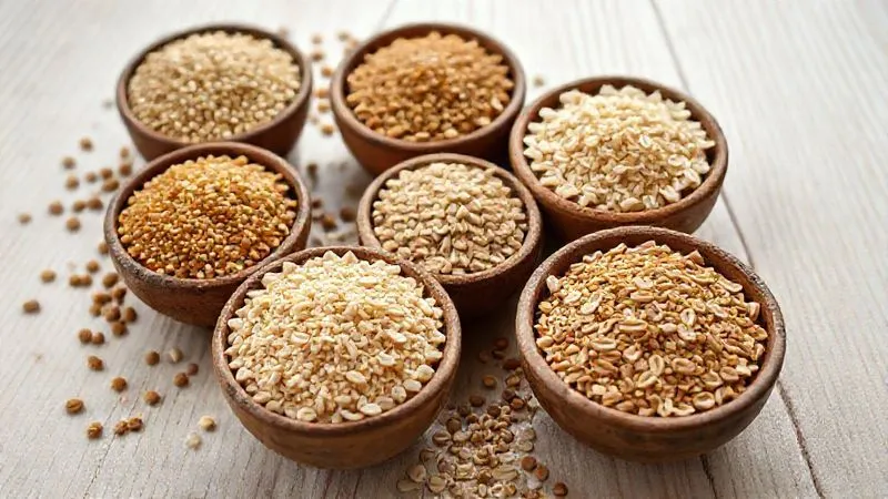 Photorealistic, professional photography of various uncooked groats (quinoa, millet, buckwheat, oats) neatly arranged in small, rustic bowls on a light wooden surface, with soft, natural light highlighting their textures and colors. 8K, cinematic lighting, sharp focus on the grains, depth of field blurring the background, shot on a high-end DSLR.