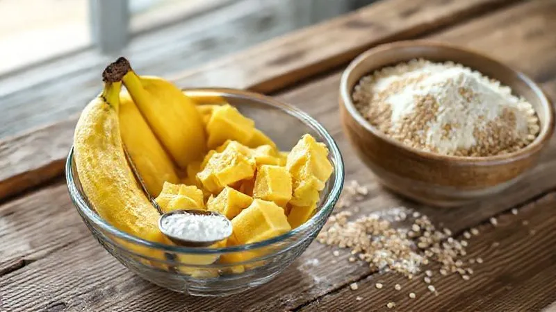 Photorealistic image of a bowl with very ripe, mashed bananas, a measuring spoon with a natural sweetener (erythritol), and a bowl of whole grain spelt flour, all arranged on a rustic wooden table in soft, natural light, 8K, sharp focus on the ingredients, depth of field blurring the background.