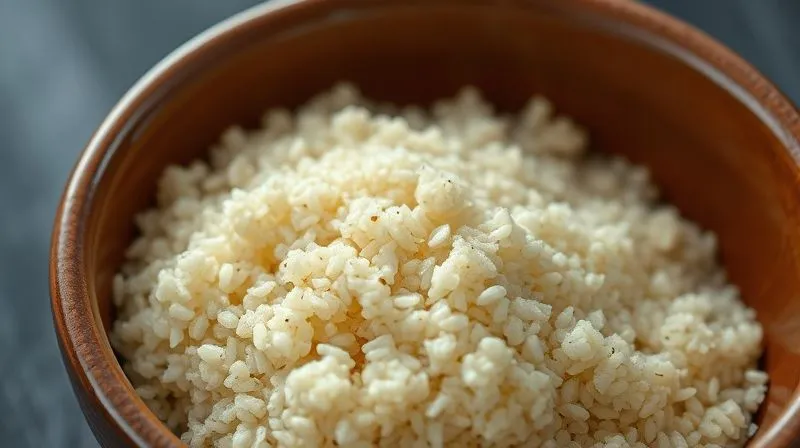 A close-up, photorealistic image of perfectly cooked, fluffy quinoa in a ceramic bowl, with individual grains clearly separated and a slight steam rising. The lighting is soft and natural, emphasizing its texture and freshness. Professional photography, 8K, cinematic lighting, sharp focus, depth of field, shot on a high-end DSLR.