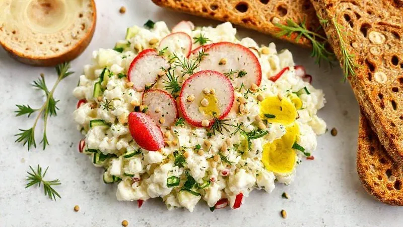 A professional, photorealistic flat lay of a savory protein cottage cheese breakfast. The cottage cheese is mixed with finely diced cucumbers, radishes, and fresh dill, topped with a drizzle of olive oil and toasted pumpkin seeds. A side of whole-grain crispbread is visible. The scene is well-lit with soft, natural light, emphasizing freshness and health. professional photography, 8K, cinematic lighting, sharp focus, depth of field, shot on a high-end DSLR.
